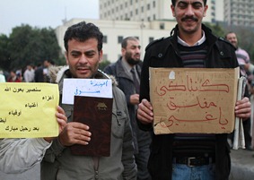 The placard held by the man on the RHS reads: "Kentucky (KFC) is closed, stupid!"